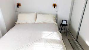 - un lit blanc avec deux oreillers dans l'établissement Donado centro, à Bahía Blanca