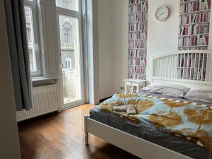 een slaapkamer met een bed en een groot raam bij Tea Liu Apartment in Boedapest