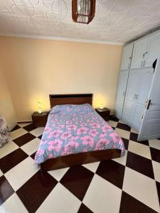 1 dormitorio con 1 cama y suelo a cuadros en Charmant Appartement vue sur mer en Argel