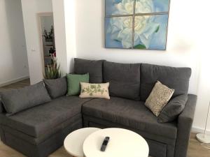 a living room with a gray couch and a white table at Puerta del Buey Apartamentos in Niebla