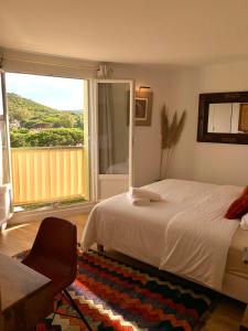 a bedroom with a bed and a large window at Luxury Apartment St-Tropez/ 10mn walk to center. in Saint-Tropez