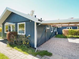 a blue house with a porch and a patio at 7 person holiday home in Holbæk-By Traum in Holbæk