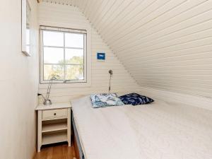 een kleine slaapkamer met een bed en een raam bij Holiday home Hals XIV in Hals