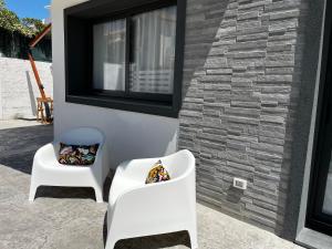 dos sillas blancas sentadas junto a un edificio con ventana en Le spiagge di Avola: Casa della Musica, en Avola