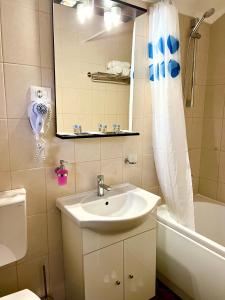 a bathroom with a sink and a mirror and a tub at Casa Servus in Mamaia Sat/Năvodari +208 photos