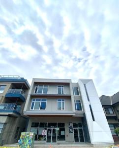 a tall building with a cloudy sky in the background at Lovely Brand New Condo in Sidney