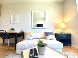 a living room with a white couch and a desk at Lovely Brand New Condo in Sidney