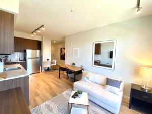 a living room with a white couch and a kitchen at Lovely Brand New Condo in Sidney