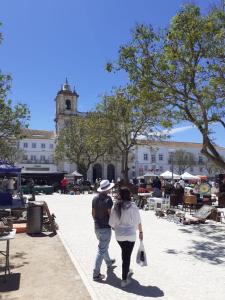 un hombre y una mujer caminando por una acera en Casa Porta do Sol, en Estremoz