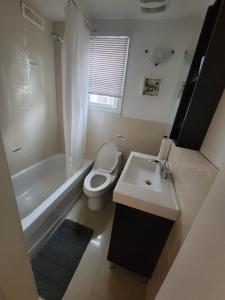 a bathroom with a toilet and a sink and a tub at 4 Bedroom 3 bathroom 6 queen bed 5 full floor mattress with backyard Whole house for travel or vacation public and celebration group gatherings in Toronto