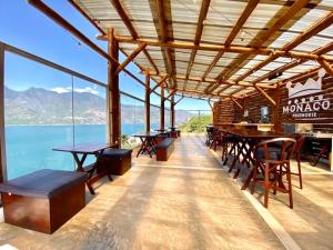 a restaurant with tables and chairs and a view of the ocean at Monaco in San Pedro La Laguna