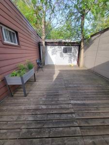 a wooden deck with a bench next to a building at 4 Bedroom 3 bathroom 6 queen bed 5 full floor mattress with backyard Whole house for travel or vacation public and celebration group gatherings in Toronto