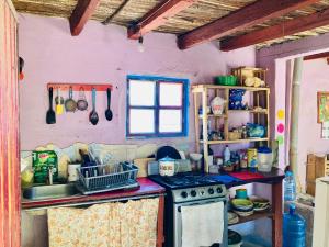 eine Küche mit einem Herd, einem Waschbecken und einem Fenster in der Unterkunft Estación de sueños Casa de Silvia in San Rafael de las Torres