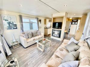 a living room with a couch and a tv at Modern 6 Berth Caravan At Highfield Grange Near Clacton-on-sea Ref 26302e in Clacton-on-Sea