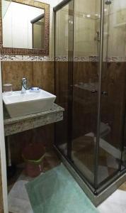 ein Bad mit einer Glasdusche und einem Waschbecken in der Unterkunft Copacabana Studio in Rio de Janeiro