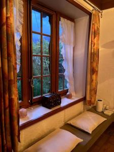 ein Fenster in einem Zimmer mit Kissen und Fensterbrett in der Unterkunft Romantische Oase mit Kamin in Unterseen