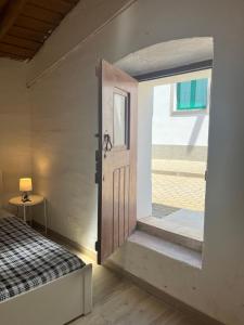 a door to a bedroom with a bed and a window at Zena Houses-Casa Rural tranquila perto de Mértola in Beja