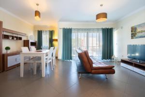 a living room with a table and a dining room at Apartamento Mãe Soberana in Loulé