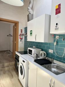 a kitchen with a sink and a washing machine at Zena Houses-Casa Rural tranquila perto de Mértola in Beja