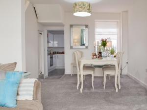 a dining room with a white table and chairs at Bwthyn Cerrigos in Milford Haven