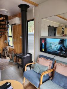 a living room with a fireplace and a stove at Delightful Container House with Views in Hartley