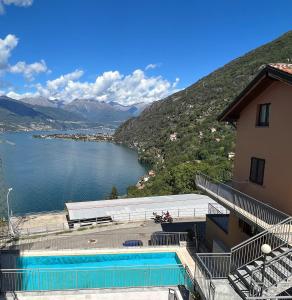 a building with a swimming pool next to a body of water at Belvedere in Costa - Lake View in Bellano