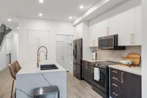 a kitchen with white cabinets and black appliances at Jewel of Blue Mountain in Blue Mountains