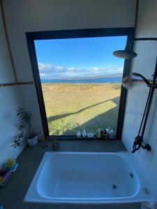 eine Badewanne in einem Zimmer mit einem großen Fenster in der Unterkunft Casa Aoni in Puerto Natales