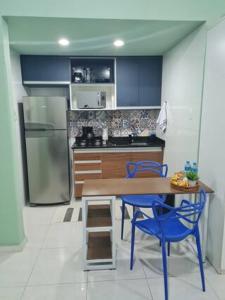 La cuisine est équipée d'une table, de chaises et d'un réfrigérateur. dans l'établissement Estúdio 2 min Praia Copacabana - Área Nobre, à Rio de Janeiro