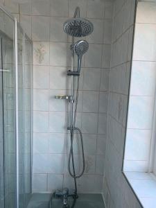 a shower with a shower head in a bathroom at Byron View House in Luton