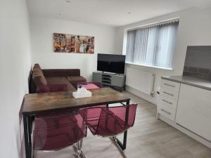 a living room with a table and a couch at Hazel 1-Bed Flat (4) + Parking in Kidlington