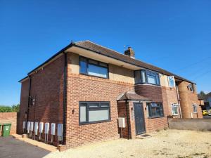 a red brick house with a blue sky at Hazel 1-Bed Flat (4) + Parking in Kidlington
