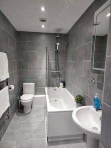 a bathroom with a tub and a toilet and a sink at Hazel 1-Bed Flat (4) + Parking in Kidlington