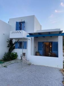 a white house with blue windows and a balcony at Mpasales house in Skiros