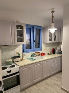 a kitchen with blue cabinets and a stove top oven at Mpasales house in Skiros