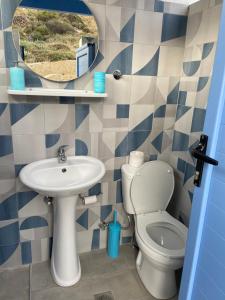 a bathroom with a sink and a toilet and a mirror at Mpasales house in Skiros