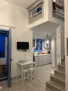 a kitchen with a white table and a tv on the wall at Mpasales house in Skiros