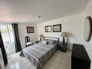 a bedroom with a bed and a large window at Casa Mediterraneo in Ensenada