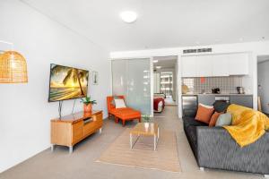 a living room with a couch and a table at 703 Harbour Lights Cairns Apartment with water views in Cairns