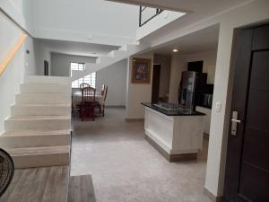 a living room with a staircase and a kitchen with a table at Casa Blanca in Reynosa