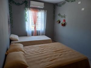 two beds in a room with a window at Casa Blanca in Reynosa