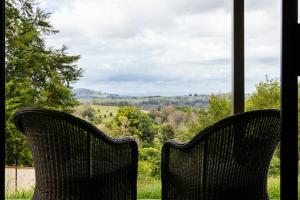 two chairs sitting in front of a window with a view at Invercauld House in Goonellabah