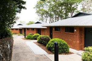 a row of brick houses with bushes and trees at Invercauld House in Goonellabah