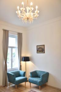 a living room with two blue chairs and a chandelier at Be Inspired, Choose The Best! in Vienna