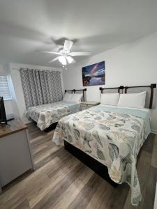 een slaapkamer met 2 bedden en een plafondventilator bij Crystal Sands Apartments in Ocean City