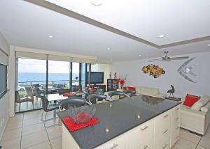 a kitchen and living room with a view of the ocean at Luxurious Beachfront Apartment in Hervey Bay