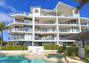 ein Gebäude mit einem Pool und einem Resort in der Unterkunft Luxurious Beachfront Apartment in Hervey Bay