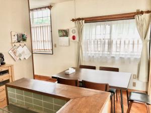 a dining room with a table and chairs at ゲストハウス奄美ルリカケス in Amami +8 photos