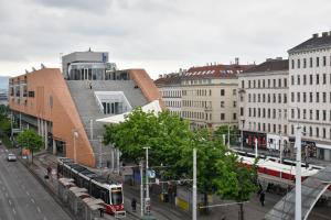eine belebte Stadtstraße mit Bussen und Gebäuden in der Unterkunft Be Inspired, Choose The Best! in Wien