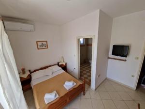 a small bedroom with a bed and a television at Villa Gabriel in Pag